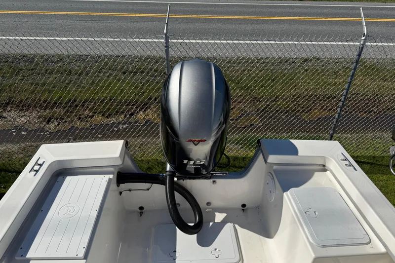 Slide: The Image of 2024 May-Craft 1900CC boat with Yamaha 115 outboard motor, parked near a chain-link fence. - 9