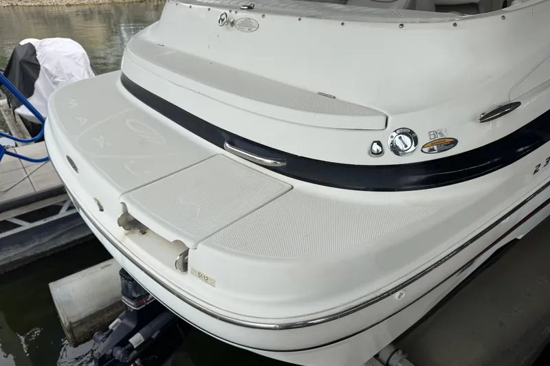 Slide: The Image of 2002 Maxum 2300 Premiere Edition boat docked, showcasing rear deck and branding. - 4