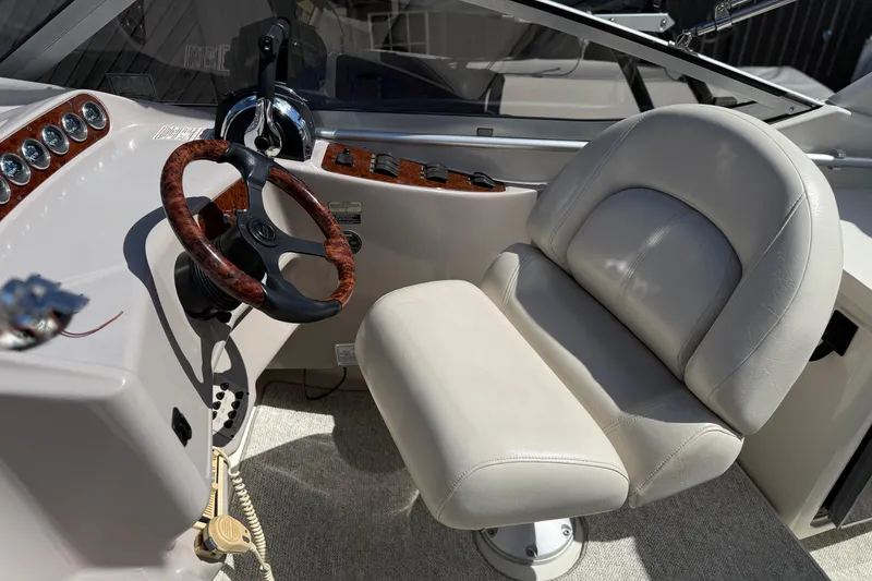 Slide: The Image of Captain's seat and helm of 2000 Regal Commodore 2960 boat, featuring wood accents. - 12