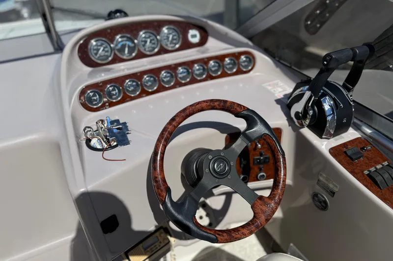 Slide: The Image of Steering console of a 2000 Regal Commodore 2960 boat with wood accents and gauges. - 13
