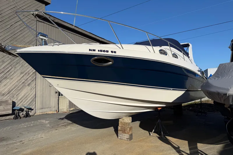 Slide: The Image of 2000 Regal Commodore 2960 boat on dry dock, blue and white hull, sunny day. - 15