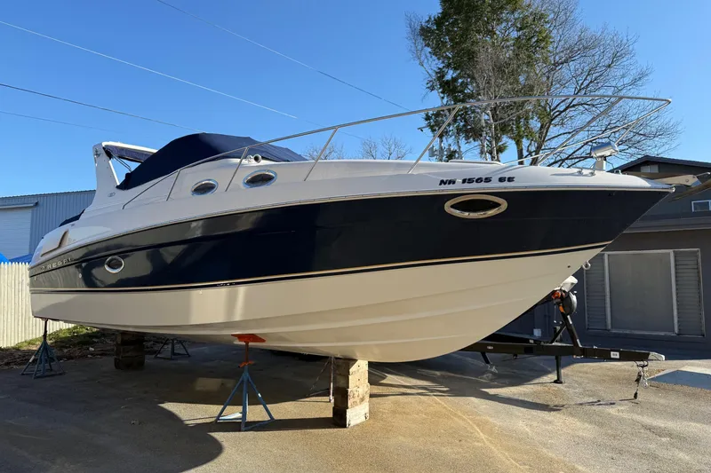 Slide: The Image of 2000 Regal Commodore 2960 boat on stands, parked outdoors near buildings. - 16