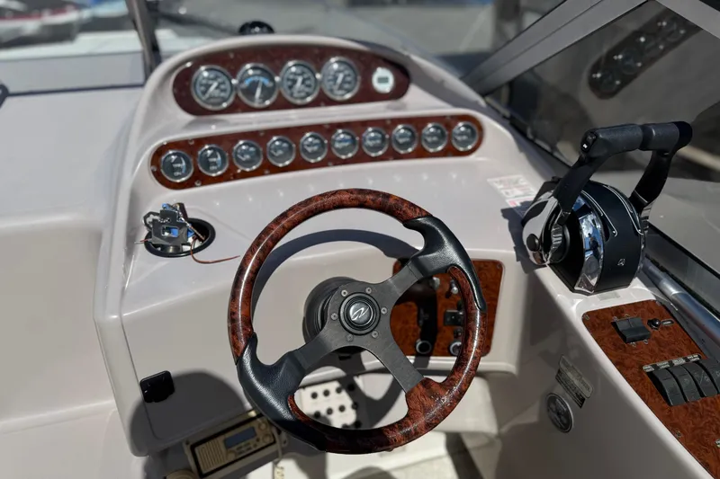 Slide: The Image of Steering console of a 2000 Regal Commodore 2960 boat with wood accents and gauges. - 9