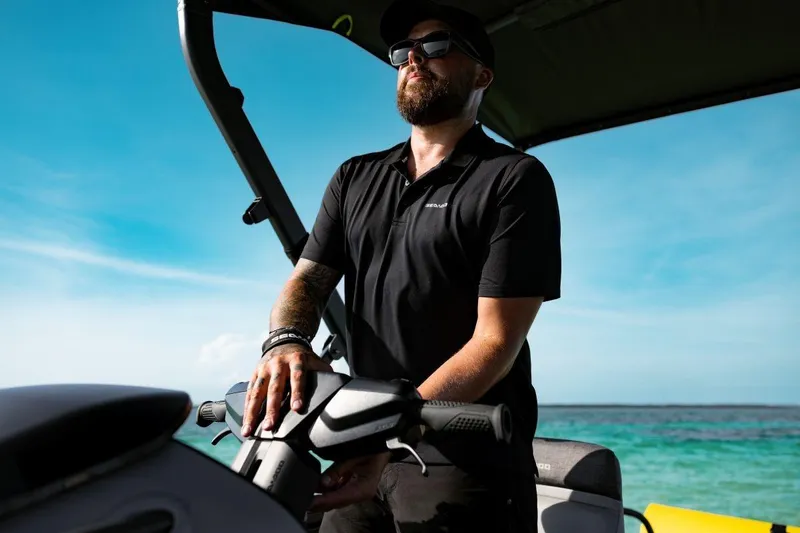 Slide: The Image of Man steering 2026 Sea-Doo Switch Fish 21 on a sunny day at sea. - 8