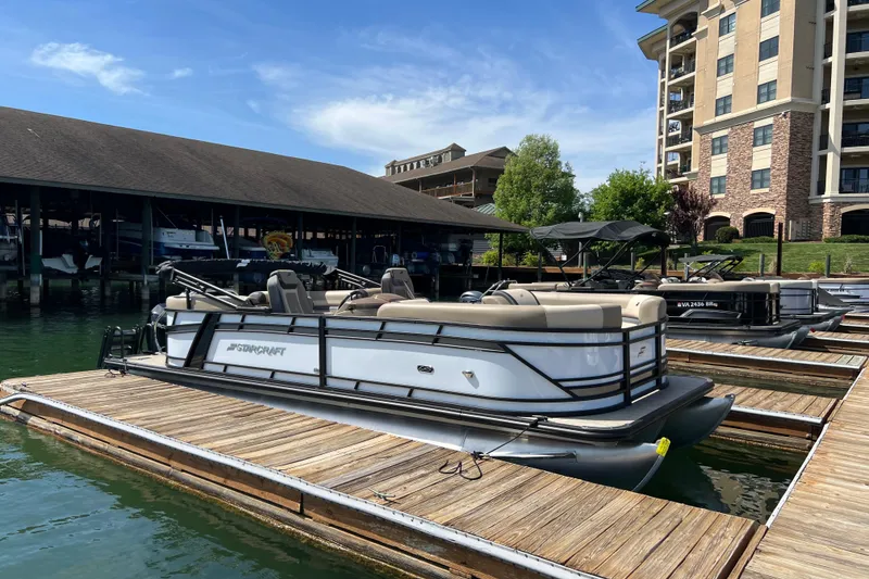 The Image of 2026 Starcraft EXS 3 R DH pontoon boat docked at marina, sunny day. - 0