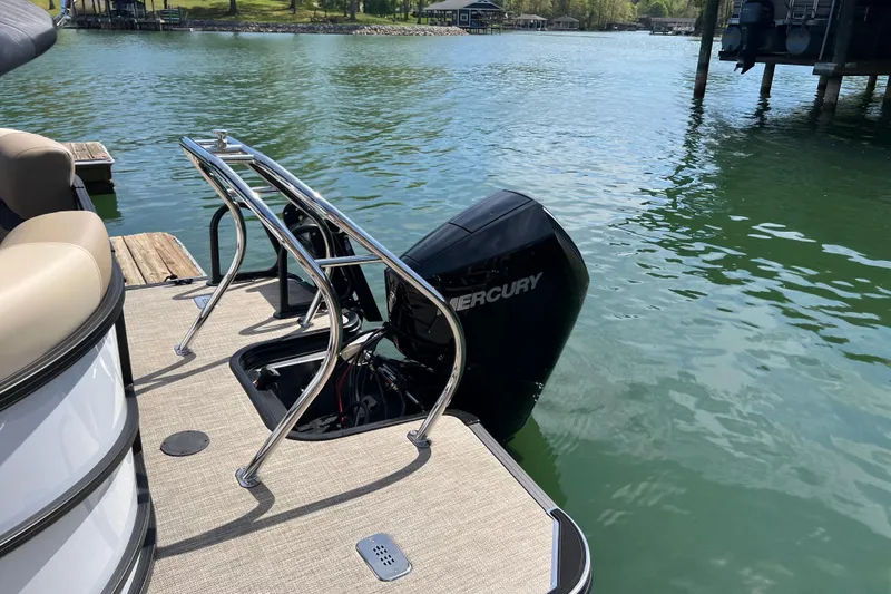Slide: The Image of 2026 Starcraft EXS 3 R DH pontoon boat with Mercury outboard motor on a serene lake. - 13