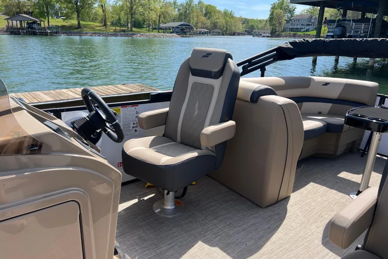 Slide: The Image of 2026 Starcraft EXS 3 R DH pontoon boat interior with plush seating by a serene lake. - 6