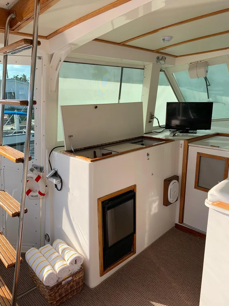 Slide: The Image of 1987 Bertram Motor Yacht interior with kitchenette, TV, and wooden accents. - 6