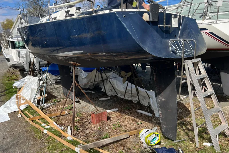 Slide: The Image of 1998 J Boats J/120 sailboat on stands, undergoing maintenance in a boatyard. - 3