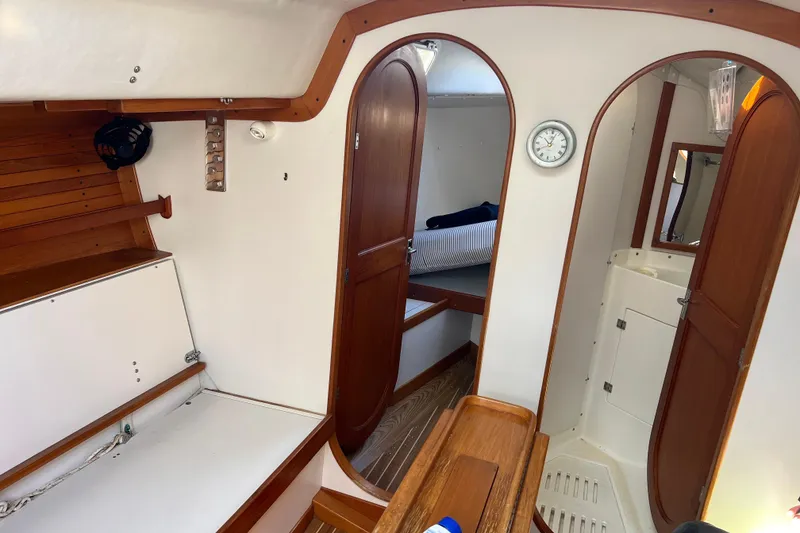 Slide: The Image of 1998 J Boats J/120 interior with wood accents, showing cabin and bathroom areas. - 5