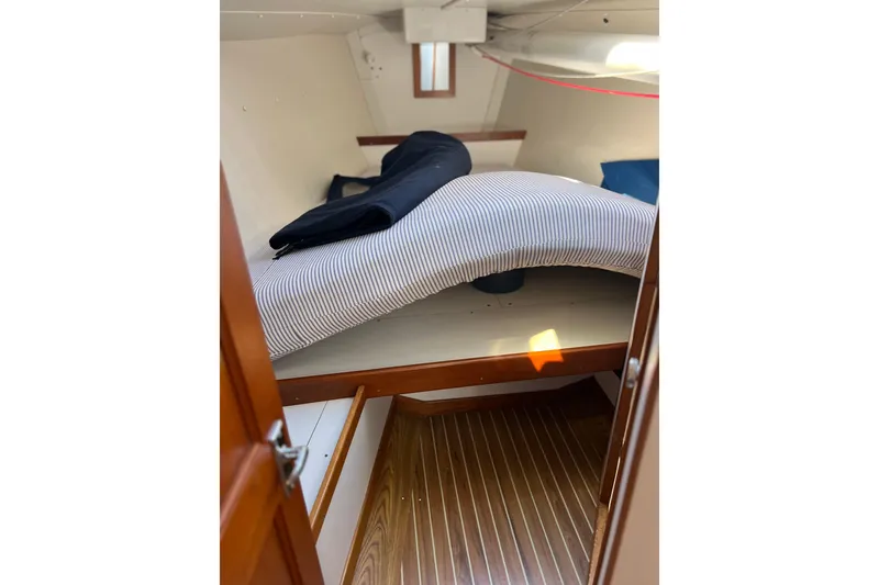 Slide: The Image of 1998 J Boats J/120 cabin interior with striped bedding and wooden flooring. - 7
