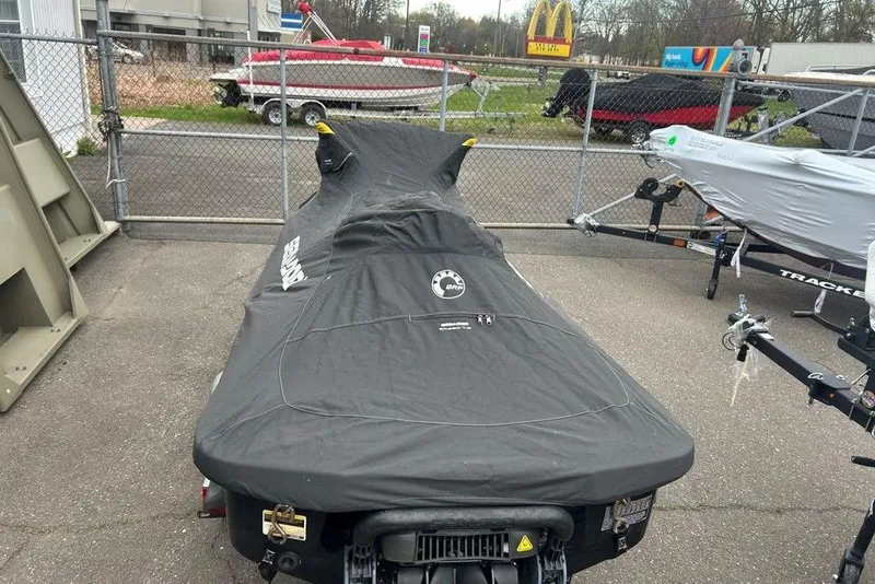 Slide: The Image of 2014 Sea-Doo Wake Pro 215 covered, parked in a lot with trailers nearby. - 10