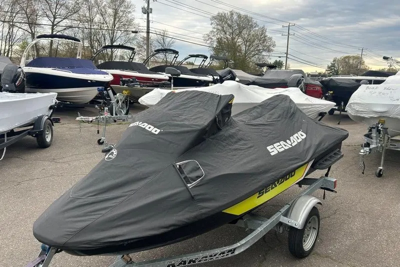 Slide: The Image of 2014 Sea-Doo Wake Pro 215 covered on trailer, surrounded by boats in a lot. - 11