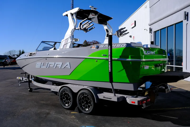 Slide: The Image of 2024 Supra SA 450 boat with vibrant green and gray design on a trailer. - 3