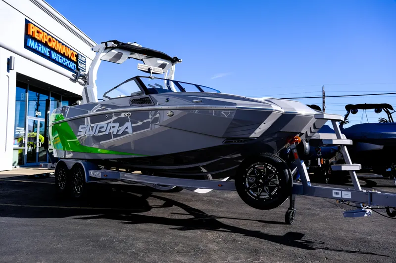 Slide: The Image of 2024 Supra SA 450 boat on trailer outside Performance Marine Watersports store. - 7