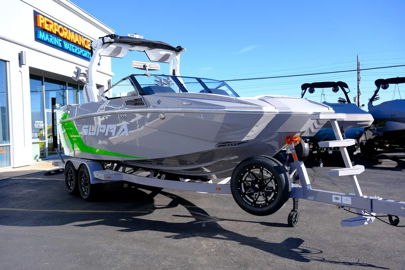 Slide: The Image of 2024 Supra SA 450 boat on trailer at Performance Marine Watersports dealership. - 8