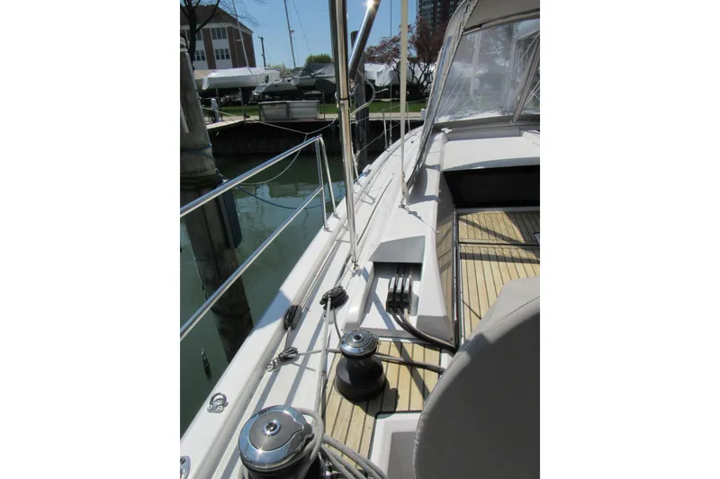Slide: The Image of 2020 Beneteau Oceanis 46.1 yacht deck with winches and railing in marina setting. - 15