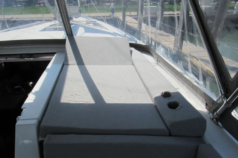 Slide: The Image of Beneteau Oceanis 46.1 (2020) yacht deck with cushioned seating and cup holders. - 50