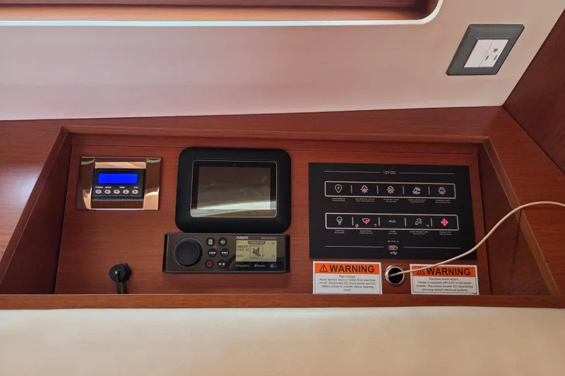 Slide: The Image of Control panel of a 2020 Beneteau Oceanis 46.1 yacht with electronic displays and warning labels. - 56