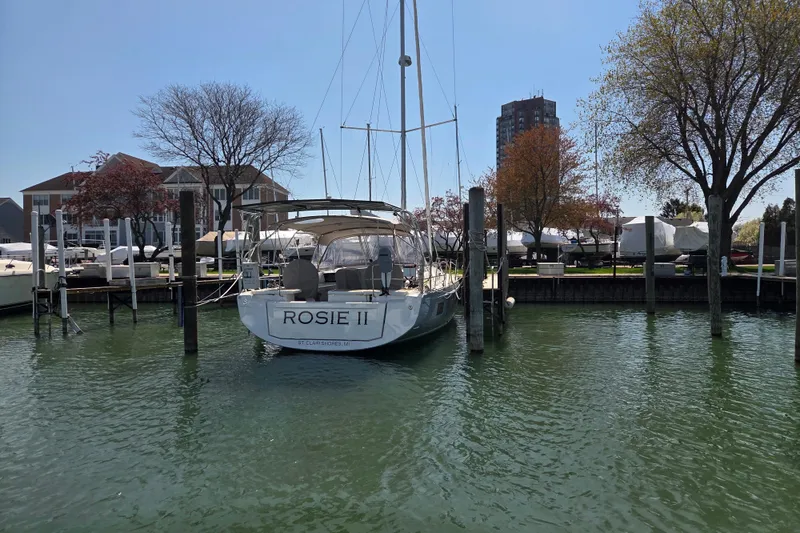 Slide: The Image of Beneteau Oceanis 46.1 sailboat docked in a marina, surrounded by trees and buildings. - 8
