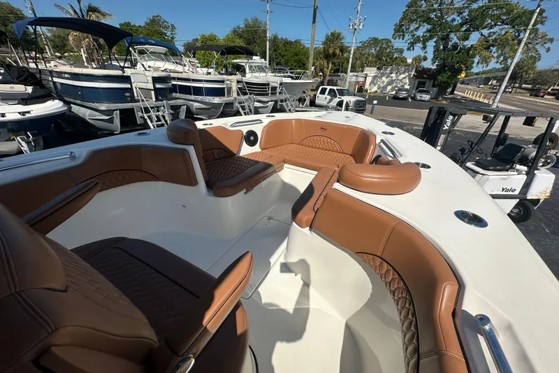 Slide: The Image of 2021 Key West 263 FS boat interior with brown seating, docked among other boats. - 10