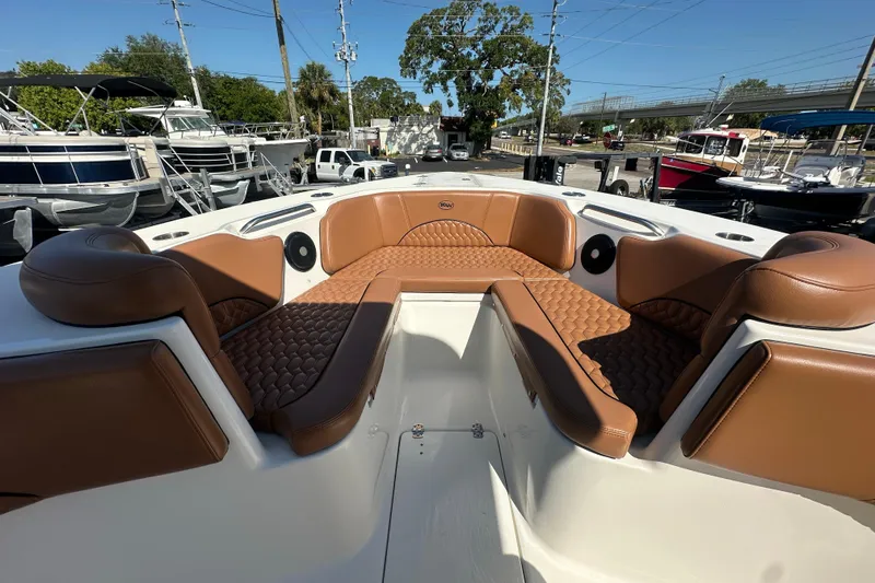 Slide: The Image of 2021 Key West 263 FS boat interior with brown cushioned seating in a marina setting. - 11