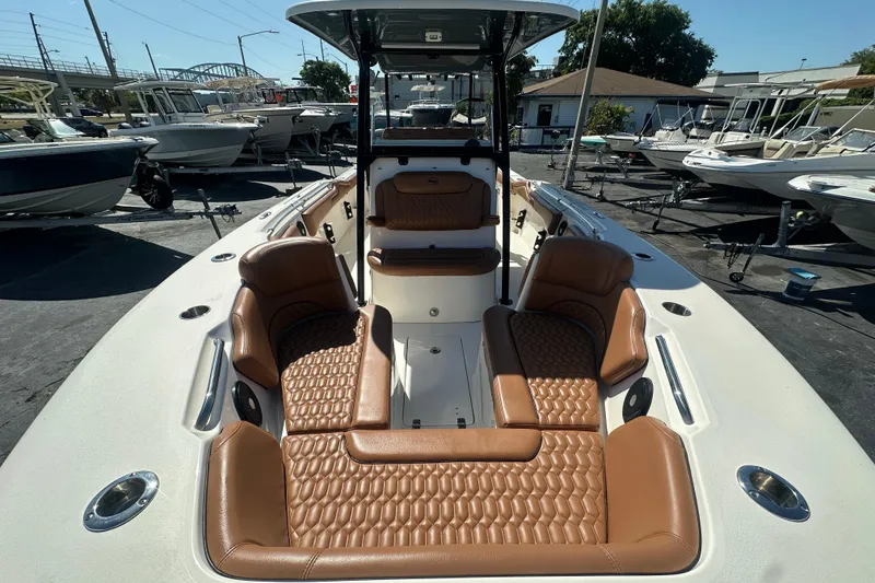 Slide: The Image of 2021 Key West 263 FS boat with luxurious brown seating, displayed in a marina. - 13