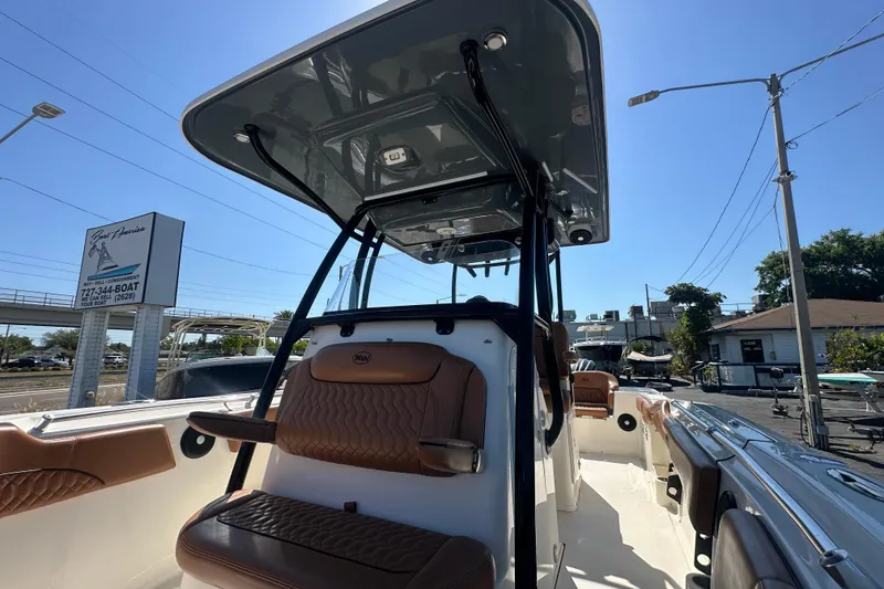 Slide: The Image of 2021 Key West 263 FS boat with brown seating and T-top, parked outdoors. - 15