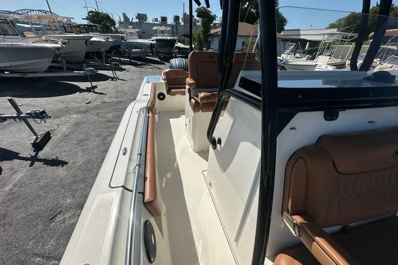 Slide: The Image of 2021 Key West 263 FS boat with tan seating, docked among other boats. - 16