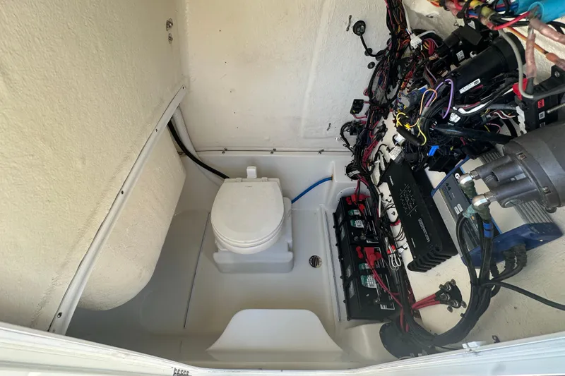 Slide: The Image of Interior of a 2021 Key West 263 FS boat showing wiring and marine toilet setup. - 18