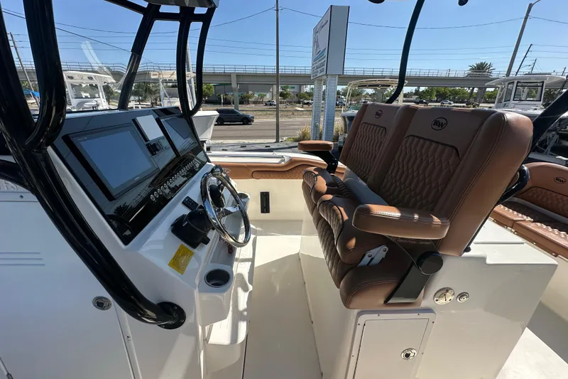 Slide: The Image of 2021 Key West 263 FS boat interior with dual brown leather seats and modern dashboard. - 19