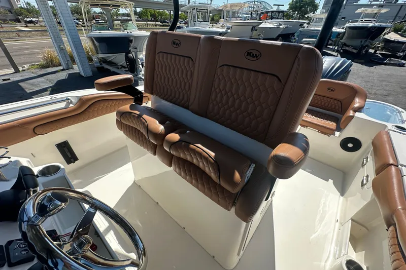 Slide: The Image of 2021 Key West 263 FS boat interior with brown leather seating and steering wheel. - 20