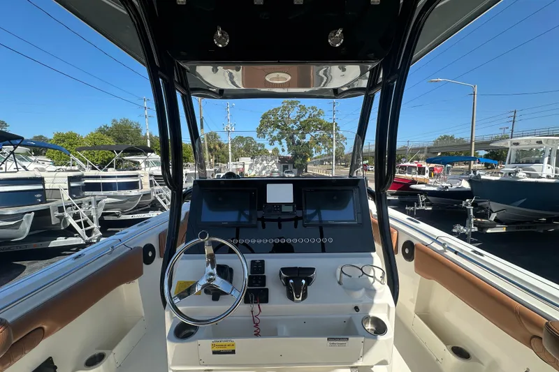 Slide: The Image of 2021 Key West 263 FS boat dashboard with steering wheel and navigation display. - 21