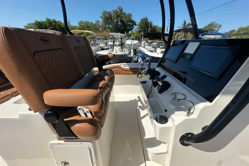 Slide: The Image of 2021 Key West 263 FS boat interior with brown seating and modern dashboard. - 23