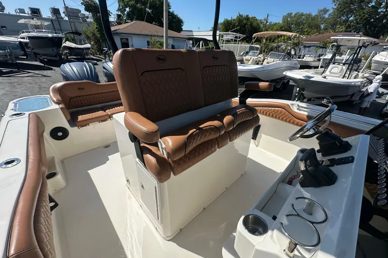 Slide: The Image of 2021 Key West 263 FS boat interior with brown seating and steering console. - 24