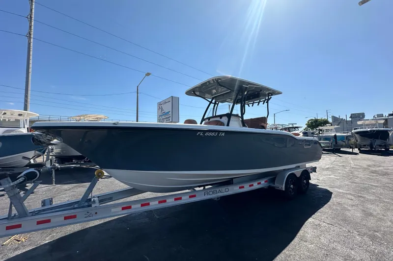 Slide: The Image of 2021 Key West 263 FS boat on trailer under clear blue sky. - 8