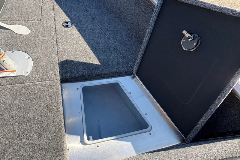 Slide: The Image of 2026 Lund 1875 Impact XS Sport boat interior storage compartment with open hatch. - 11