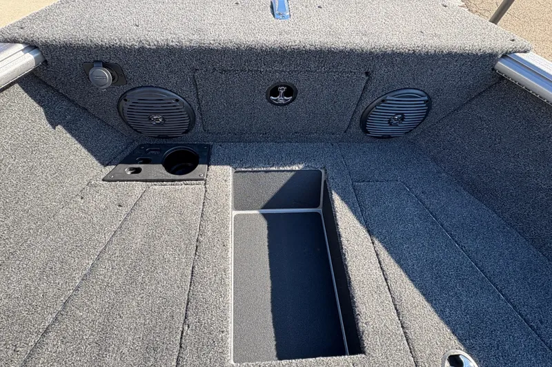 Slide: The Image of Interior of 2026 Lund 1875 Impact XS Sport boat, featuring carpeted flooring and storage compartments. - 14