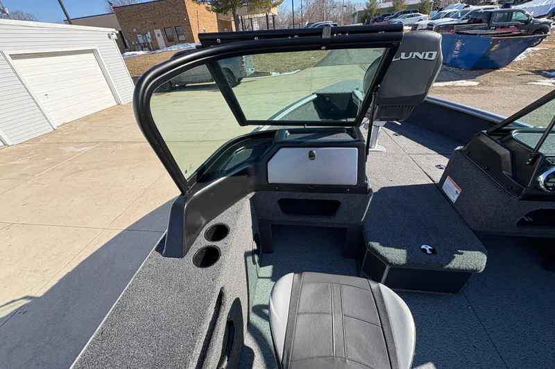 Slide: The Image of 2026 Lund 1875 Impact XS Sport boat interior with seating and windshield. - 18