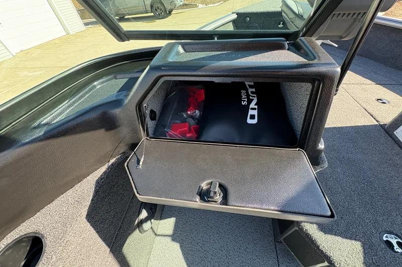Slide: The Image of Storage compartment of 2026 Lund 1875 Impact XS Sport boat, open with visible contents. - 19