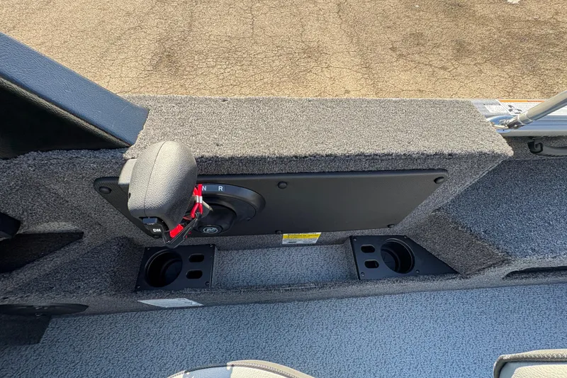 Slide: The Image of 2026 Lund 1875 Impact XS Sport boat interior with control panel and cup holders. - 22