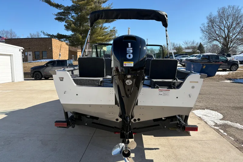 Slide: The Image of 2026 Lund 1875 Impact XS Sport boat with 150 HP engine, parked outdoors. - 3