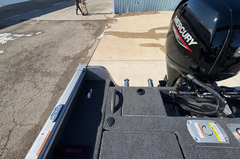 Slide: The Image of 2026 Lund 1875 Impact XS Sport boat with Mercury engine, parked on pavement. - 31