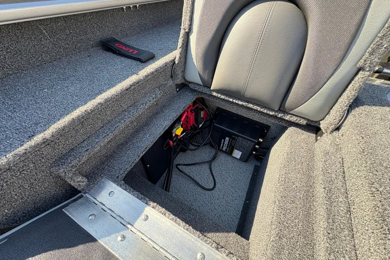 Slide: The Image of 2026 Lund 1875 Impact XS Sport boat interior with storage compartment and wiring. - 32