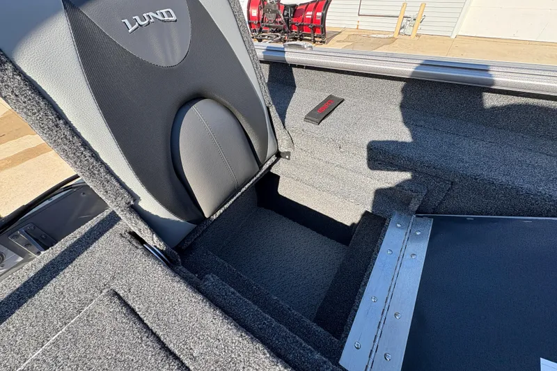 Slide: The Image of 2026 Lund 1875 Impact XS Sport boat interior with gray seating and storage compartment. - 33