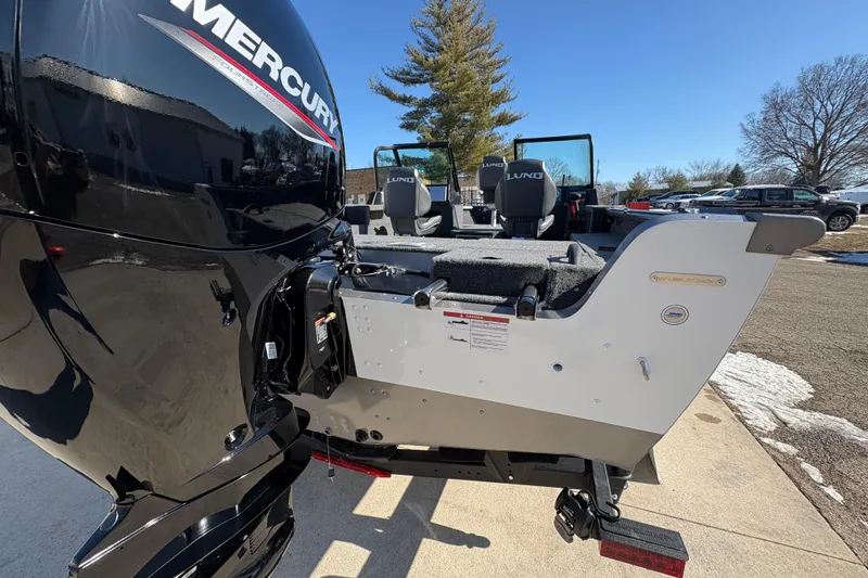 Slide: The Image of 2026 Lund 1875 Impact XS Sport boat with Mercury engine, parked outdoors. - 35