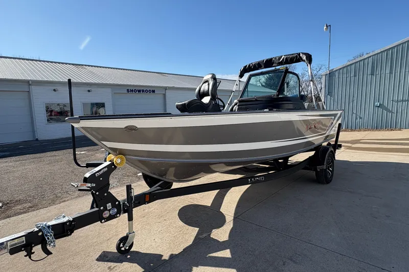 Slide: The Image of 2026 Lund 1875 Impact XS Sport boat on trailer outside showroom. - 6