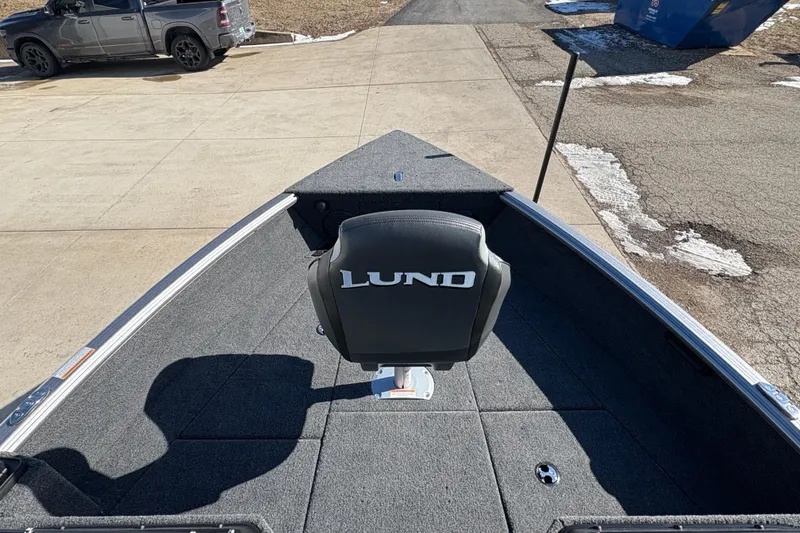 Slide: The Image of 2026 Lund 1875 Impact XS Sport boat interior with branded seat on a sunny day. - 9