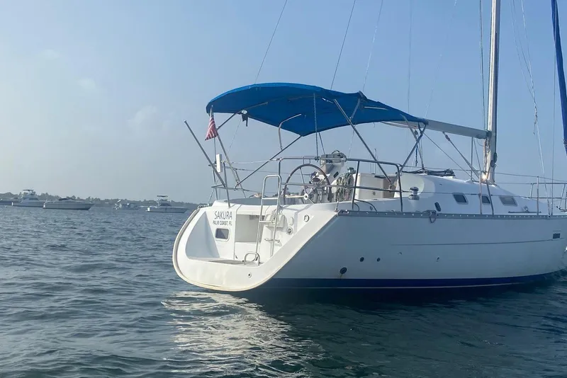 Slide: The Image of 2006 Beneteau Oceanis Clipper 323 sailboat with blue canopy on calm water. - 12