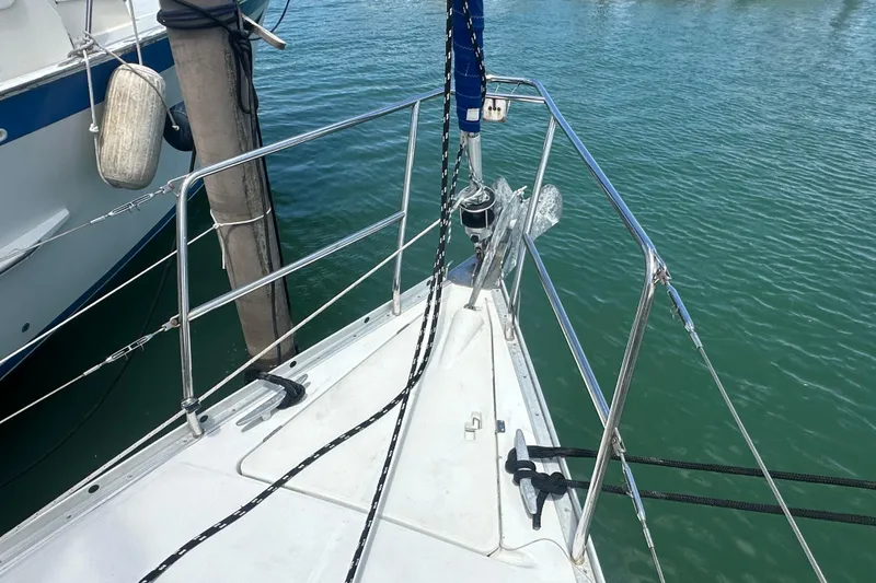 Slide: The Image of Bow of 2006 Beneteau Oceanis Clipper 323 sailboat docked in calm marina waters. - 16